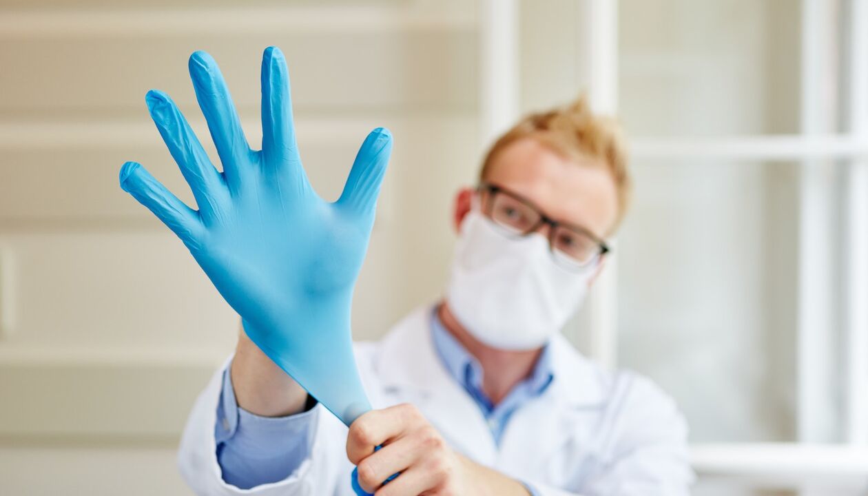 Der Arzt zieht einen Handschuh an, um Prostatitis zu massieren und zu verhindern